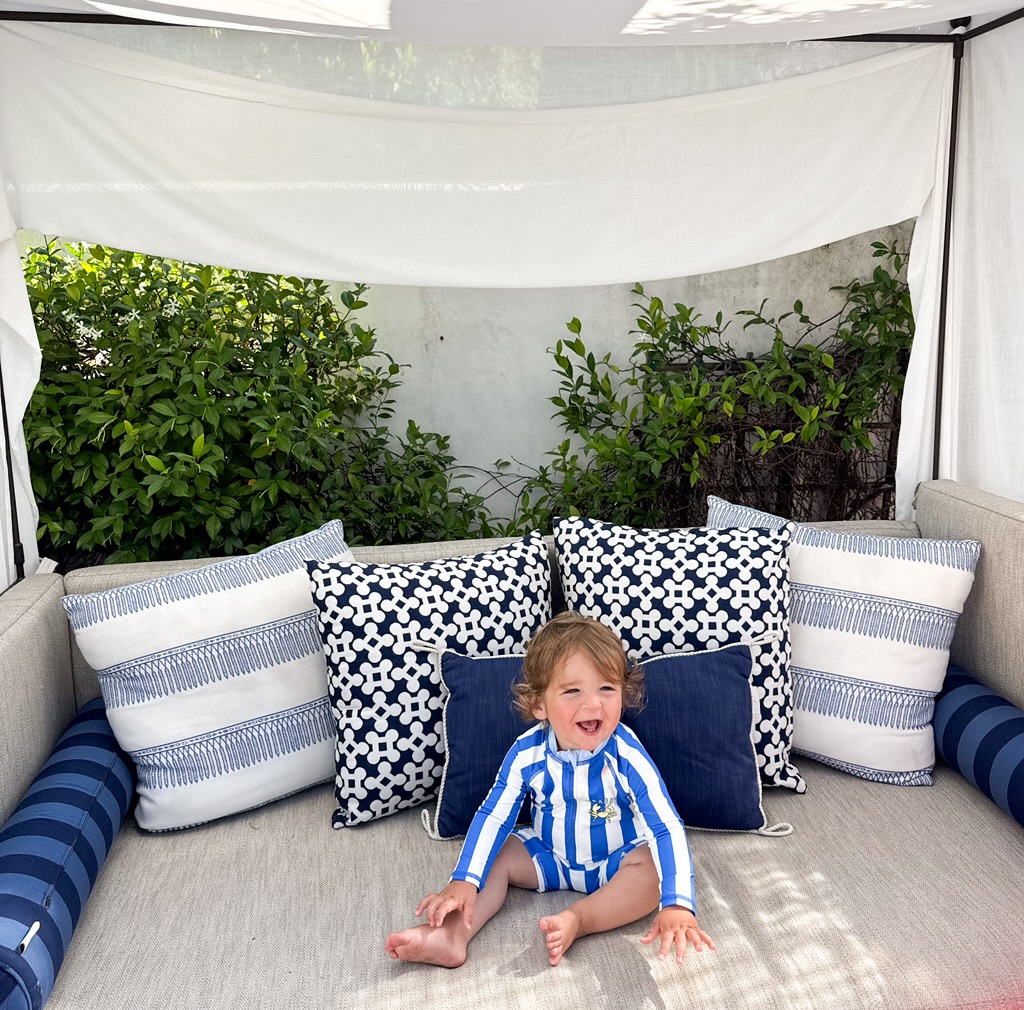 Striped cabanas and yellow umbrellas beside a hotel pool